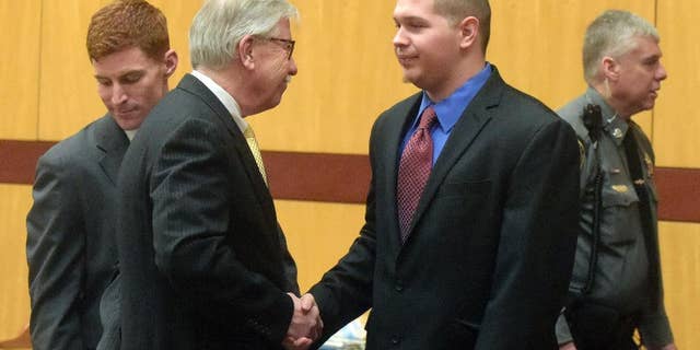 Defendant Tony Moreno, center right, shakes hands with Frederick O'Brien, one of his defense attorneys, after walking into a courtroom at Middletown Superior Court, Friday, Feb. 10, 2017, in Middletown, Conn. Moreno is charged with killing his 7-month-old son by throwing the boy off a bridge. (Patrick Raycraft/Hartford Courant via AP, Pool)