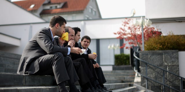 PFAEFFIKON, SWITZERLAND - OCTOBER 06: Four men eat sandwiches during lunch time as they sit on the steps of the village square on October 6, 2009 in Pfaeffikon, Switzerland. Due to lower taxes and less regulation the small Swiss town on the shores of lake Zurich has become a hedge fund hot spot. (Photo by Miguel Villagran/Getty Images)