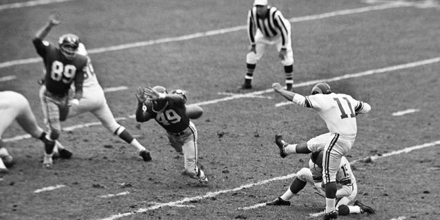 In this Oct. 22, 1961, file photo, New York Giants halfback Erich Barnes (49) blocks field goal-attempt by Los Angeles Rams' Danny Villanueva (11) in the first period of NFL game in New York's Yankee Stadium. Villanueva, who was one of the NFL’s first Latino kickers and a pioneer of Spanish-language television, has died. He was 77. (AP Photo, File)