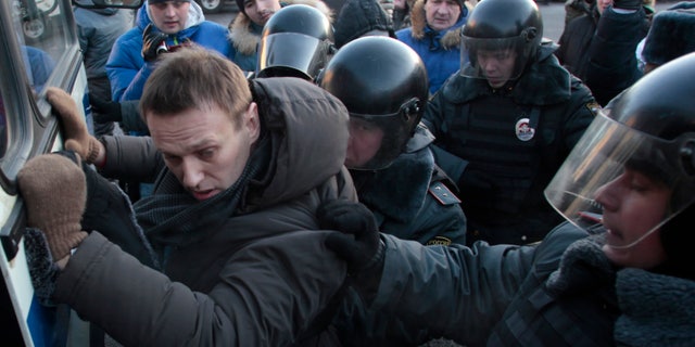 FILE - In this Saturday, Dec. 15, 2012 file photo police officers detain opposition leader Alexei Navalny during an unauthorized rally in Lubyanka Square in Moscow. Navalny, who helped organized the largest anti-Kremlin rallies in Russia's post-Soviet history, was charged with fraud and money-laundering Thursday. (AP Photo/Pavel Golovkin, File)