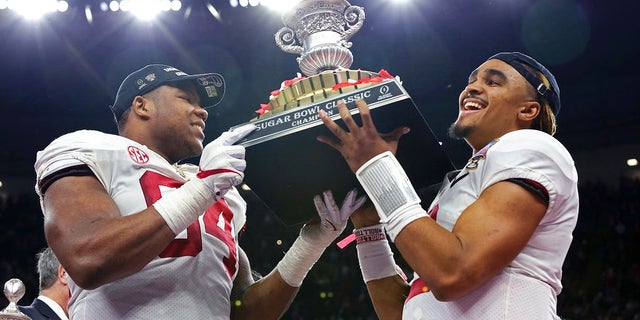 Alabama players D'Ron Payne, left, and Jalen Hurts hoist the Sugar Bowl trophy after Monday night's victory.