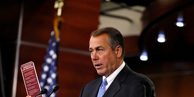 House Speaker John Boehner, R-Ohio,  holds a job brochure during a news conference on Capitol Hill in Washington.