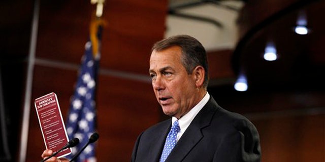 House Speaker John Boehner, R-Ohio, holds a job brochure during a news conference on Capitol Hill in Washington.