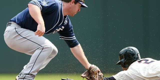 San Diego Padres second baseman Jedd Gyorko, left, reaches to tag Minnesota Twins' Brian Dozier who was called safe as he stole second base in the first inning of a baseball game, Wednesday, Aug. 6, 2014, in Minneapolis. (AP Photo/Jim Mone)