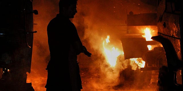 Oct. 4, 2010: A Pakistani fire fighter prepares to extinguish burning oil tankers after militants attacked a terminal in Rawalpindi, Pakistan.