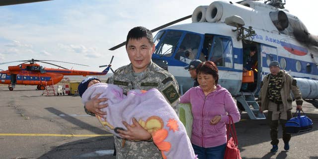 In this photo dated Wednesday, Sept. 21, 2016, provided by the Tuva Emergency Ministry Situations press service, an unidentified special force soldier carries a 3-year old boy rescued after going missing for three days in an undisclosed location in the Russian Siberian region of Tuva. The boy, who was under care of his grandmother, reportedly vanished in the woods after having followed a puppy. (Tuva Emergency Situations Ministry press service photo via AP) MANDATORY CREDIT
