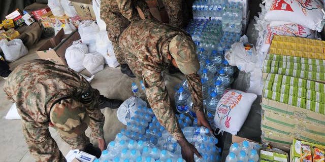 Pakistani army soldiers arrange relief supplies for earthquake survivors in Lahore on September 29, 2013.