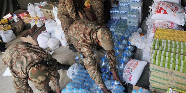 Pakistani army soldiers arrange relief supplies for earthquake survivors in Lahore on September 29, 2013.