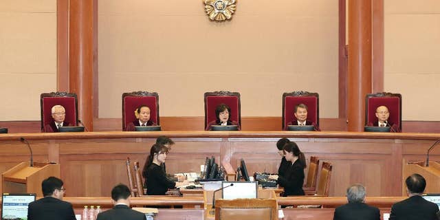 Judges of the Constitutional Court sit during a hearing on whether to confirm the impeachment of President Park Geun-hye, at the Court in Seoul, South Korea, Thursday, Feb. 9, 2017. Prosecutors say South Korea's impeached president has canceled plans to undergo questioning to protest leaks to the media about her investigation. (Kim Hyun-tae/Yonhap via AP)