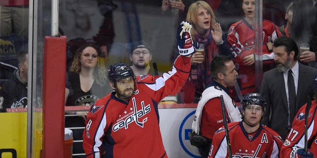 Washington Capitals left wing Alex Ovechkin (8), of Russia, waves to the crowd from the bench after he scored a goal during the first period of an NHL hockey game against the Pittsburgh Penguins, Wednesday, Jan. 11, 2017, in Washington.  Ovechkin didn't wait long to hit another milestone in his illustrious career, becoming the 84th player in NHL history to record 1,000 points.  (AP Photo/Nick Wass)