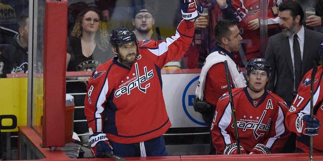 Washington Capitals left wing Alex Ovechkin (8), of Russia, waves to the crowd from the bench after he scored a goal during the first period of an NHL hockey game against the Pittsburgh Penguins, Wednesday, Jan. 11, 2017, in Washington. Ovechkin didn't wait long to hit another milestone in his illustrious career, becoming the 84th player in NHL history to record 1,000 points. (AP Photo/Nick Wass)