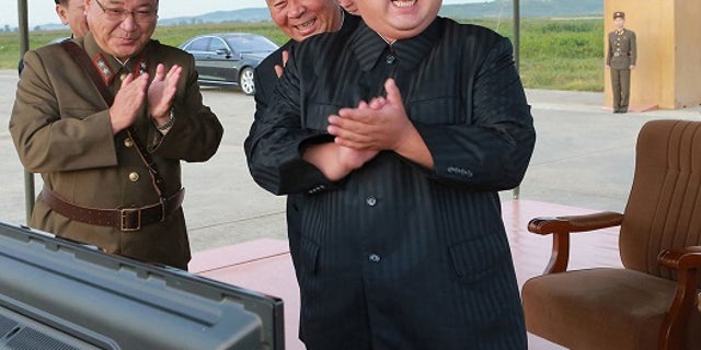 In this undated file photo distributed on Sept. 16, 2017, by the North Korean government, North Korean leader Kim Jong Un, right, celebrates what was said to be the test launch of an intermediate range Hwasong-12 missile at an undisclosed location in North Korea.