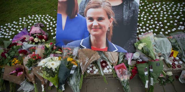 FILE - This is a Friday, June 17, 2016, file photo of an image and floral tributes for Jo Cox, in Parliament Square, outside the House of Parliament in London, after the 41-year-old British Member of Parliament was fatally injured in northern England. A jury Wednesday Nov. 23, 2016 found Thomas Mair with white supremacist views guilty of murdering Labour lawmaker Jo Cox a week before Britain's EU membership referendum. (AP Photo/Matt Dunham, File)