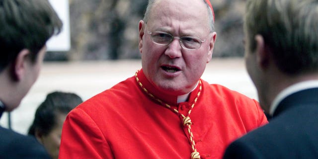 In this Saturday, Feb. 18, 2012 file photo, Cardinal Timothy Dolan, archbishop of New York, is congratulated by two unidentified prelates after being elevated in St. Peter's Basilica at the Vatican. According to a spokesman from the Archdiocese of New York City, Dolan has been deposed in New York on Wednesday, Feb. 20, 1023 in connection to accusations of sexual abuse in the Archdiocese of Milwaukee. (AP Photo/Andrew Medichini, File)