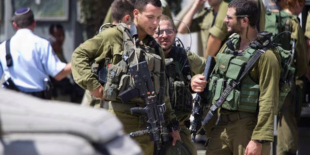 Aug. 17, 2015: Israeli soldiers stand guard at a checkpoint near the West Bank of Nablus. Israel authorities say troops have shot and killed a Palestinian after he stabbed a guard at a West Bank checkpoint. Police spokeswoman Luba Samri says the man approached border police officers manning a checkpoint on Monday and told them he felt unwell.