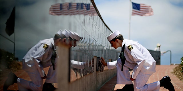 Sea Cadet Andrew Culp, 13, cleans a war memorial during a Memorial Day ceremony at the Mount Soledad Veterans Memorial in La Jolla, Calif., May 27, 2013. (Associated Press)