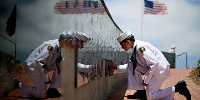 Sea Cadet Andrew Culp, 13, cleans a war memorial during a Memorial Day ceremony at the Mount Soledad Veterans Memorial in La Jolla, Calif., May 27, 2013. (Associated Press)