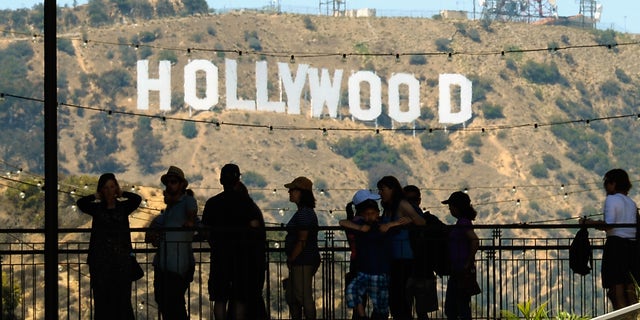 LOS ANGELES, CA - JUNE 28:  Tourists are slihouted against the distroted Hollywood sign from rising heat waves during a major heat wave in Southern California on June 28, 2013 in Los Angeles, California. Temperatures are expected to be in the triple digits in most areas of Southern California. According to the national Weather Service, the heat wave is expected to linger into early next week prompting heat advisories and opening of cooling centers.  (Photo by Kevork Djansezian/Getty Images)