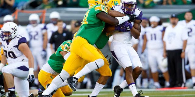 Oregon linebacker Tony Washington (91) stops Washington running back Dwayne Washington (12) during the first quarter in an NCAA college football game in Eugene, Ore., Saturday, Oct. 18, 2014. (AP Photo/Ryan Kang)