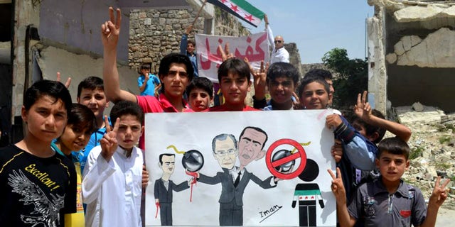 In this citizen journalism image provided by Edlib News Network, ENN, which has been authenticated based on its contents and other AP reporting, anti-Syrian regime protesters hold a poster depcting Syrian President Bashar Assad, left, Russian Foreign Minister Sergei Lavrov, center, and U.S. President Barack Obama, right during a demonstration, at Kafr Nabil town, in Idlib province, northern Syria, Friday May 10, 2013. Arabic on the banner background reads, "Kafr Nabil." (AP Photo/Edlib News Network ENN)