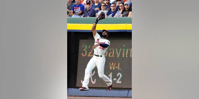 Atlanta Braves right fielder Jason Heyward fields a fly ball from Los Angeles Angels' David Freese for an out during the third inning of a baseball game on Saturday, June 14, 2014, in Atlanta. (AP Photo/David Tulis)