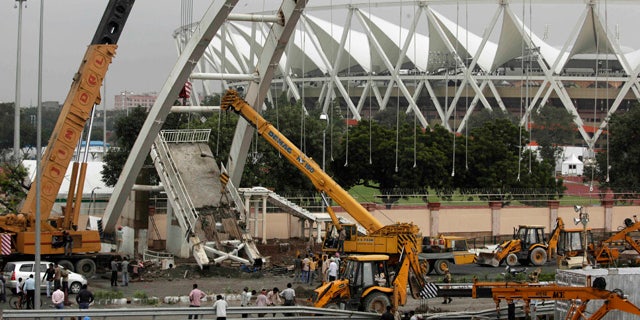Sept. 22: A crane lifts debris from a pedestrian bridge that collapsed outside the Jawaharlal Nehru Stadium, the main venue for the Commonwealth Games, in New Delhi, India.
