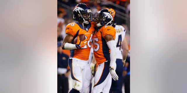 San Diego Chargers cornerback Brandon Flowers (26) celebrates his interception with teammate Chris Harris (25) during the second half of an NFL football game against the San Diego Chargers, Thursday, Oct. 23, 2014, in Denver. (AP Photo/Jack Dempsey)