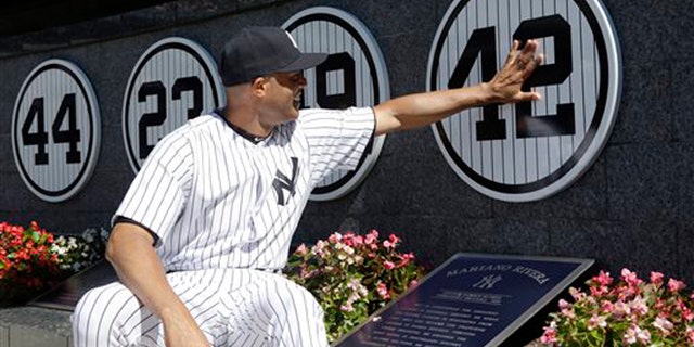 Mariano Rivera touches his plaque in Monument Park as he is honored in a pregame ceremony at Yankees Stadium, Sunday, Sept. 22, 2013, in New York.