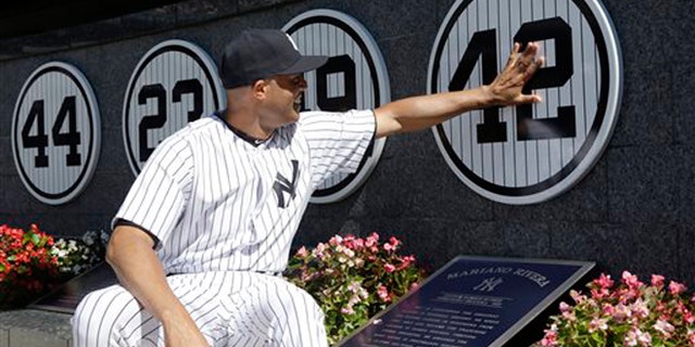 Mariano Rivera touches his plaque in Monument Park as he is honored in a pregame ceremony at Yankees Stadium, Sunday, Sept. 22, 2013, in New York.
