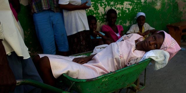 Nov.  17: A woman suffering cholera symptoms is pushed in a wheelbarrow to St. Catherine hospital in Port-au-Prince, Haiti.  Haiti’s cholera epidemic has killed at least 1,000 people and hospitalized thousands.