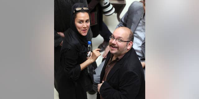 FILE - In this April 11, 2013 file photo, Jason Rezaian, right, an Iranian-American correspondent for the Washington Post, and his wife Yeganeh Salehi, an Iranian correspondent for the Abu Dhabi-based daily newspaper, The National, smile as they attend a presidential campaign of President Hassan Rouhani in Tehran, Iran. The family of Rezaian who is detained in Iran says authorities there have allowed him to hire a lawyer after more than seven months behind bars, though it is not the attorney they had hoped for. Rezaian was detained in Tehran on July 22, 2014 along with Salehi, and two photojournalists. Rezaian, who was born and spent most of his life in the United States, is the only one of the four still behind bars. (AP Photo/Vahid Salemi, File)