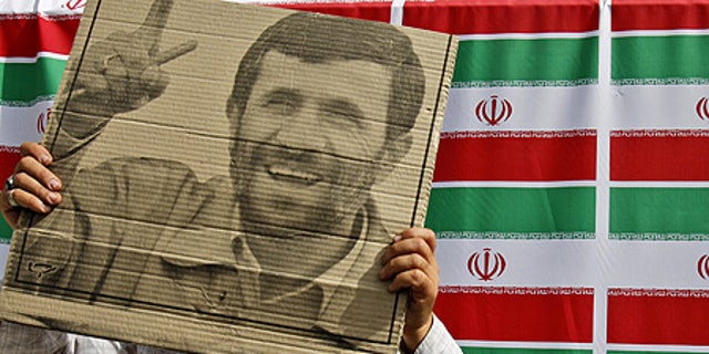 June 10: A supporter of Mahmoud Ahmadinejad holds the president's poster during a rally in west Tehran.