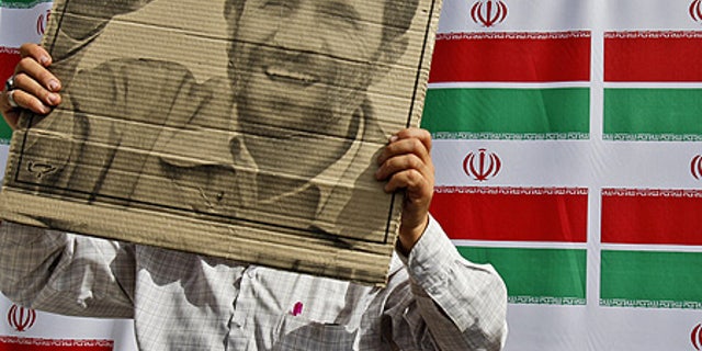 June 10: A supporter of Mahmoud Ahmadinejad holds the president's poster during a rally in west Tehran.