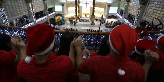 A Filipino Catholics choir hold hands as they sing during the first of nine daily dawn Masses before Christmas day at the St. Peter Parish in suburban Quezon city, north of Manila, Philippines on Wednesday, Dec. 16, 2015. This centuries-old tradition was said to have been started by farmers who wanted to fulfill their religious obligation before the day's work in the field. Christmas is the longest holiday celebration in this predominantly Roman Catholic nation.(AP Photo/Aaron Favila)