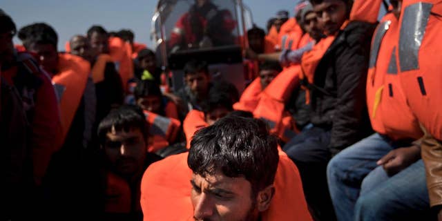 In this April 6, 2017 file photo, migrants are rescued from a rubber boat by members of Proactiva Open Arms NGO, in the Mediterranean sea, about 56 miles north of Sabratha, Libya. With the Greek smuggling route largely closed off, the path of least resistance drifted to Libya _ a sprawling lawless country with a huge coast and competing rebel and government factions. Migrants have flooded into Libya from across Africa, producing a bonanza for smugglers. (AP Photo/Bernat Armangue, File)