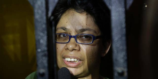 Agnes D'Souza, sister of Judith D'Souza who has allegedly been kidnapped in Afghanistan, talks to journalists from behind the front gate of their apartment in Kolkata, India, Friday, June 10, 2016. The 40-year-old worker was hired by the Aga Khan Foundation, which provides education and health assistance in about 30 countries. (AP Photo/ Bikas Das)