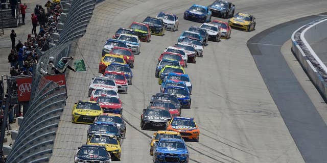 Kevin Harvick, front left, and Dale Earnhardt Jr., front right, lead the field to take the green flag to start the NASCAR Sprint Cup series auto race, Sunday, May 15, 2016, at Dover International Speedway in Dover, Del. (AP Photo/Nick Wass)