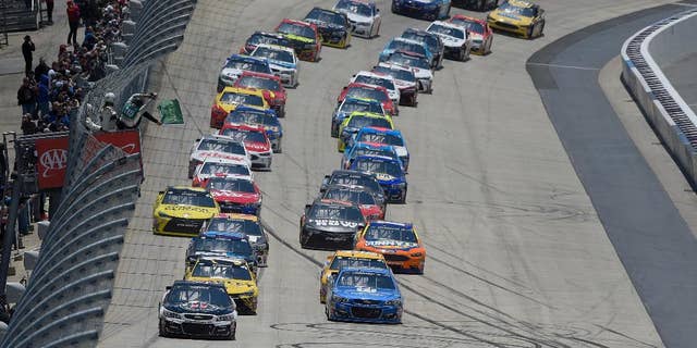 Kevin Harvick, front left, and Dale Earnhardt Jr., front right, lead the field to take the green flag to start the NASCAR Sprint Cup series auto race, Sunday, May 15, 2016, at Dover International Speedway in Dover, Del. (AP Photo/Nick Wass)