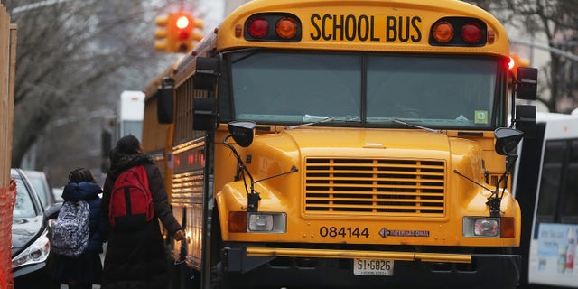 NEW YORK, NY - JANUARY 15: Students walk to board a school bus in Manhattan's East Village on January 15, 2013 in New York City. Drivers of the city's school buses are set to go on strike tomorrow after negotiations with Mayor Michael Bloomberg failed to reach an agreement; over 150,000 children will need to find an alternate method of transportation to school. (Photo by Mario Tama/Getty Images)