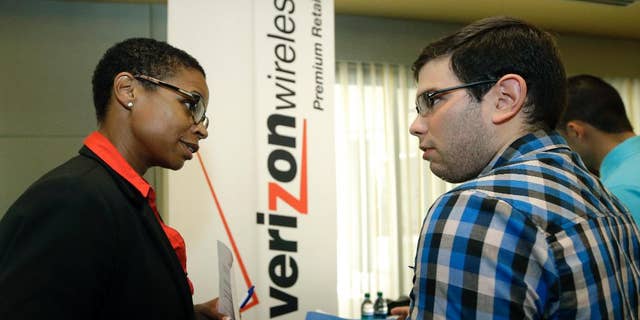 In this July 15, 2015, photo, Sasha Vitalis, left, talks about job opportunities to job seeker Omar Delgado at a job fair in Miami Lakes, Fla. Payroll processor ADP reports how many jobs private employers added in July on Wednesday, Aug. 4, 2015. (AP Photo/Alan Diaz)