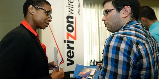 In this July 15, 2015, photo, Sasha Vitalis, left, talks about job opportunities to job seeker Omar Delgado at a job fair in Miami Lakes, Fla. Payroll processor ADP reports how many jobs private employers added in July on Wednesday, Aug. 4, 2015. (AP Photo/Alan Diaz)
