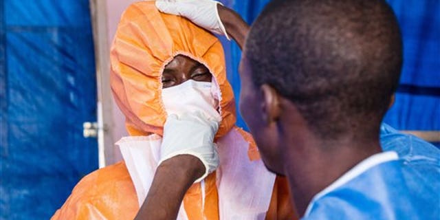 Healthcare workers wear protective gear before entering into an Ebola treatment centre in Hastings, Freetown, Sierra Leone, Wednesday, Oct. 15, 2014. Some doctors in countries hit hardest by the deadly Ebola disease decline to operate on pregnant women for fear the virus could spread. Governments face calls from frightened citizens to bar travel to and from the afflicted region. Meanwhile, the stakes get higher as more people get sick, highlighting a tricky balance between protecting people and preserving their rights in a global crisis. (AP Photo/Michael Duff)
