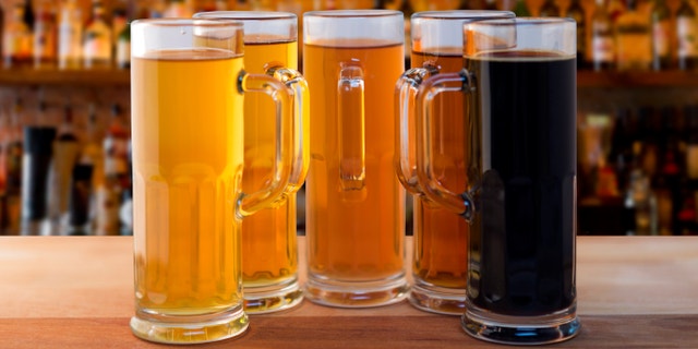 beer flight of five sampling mugs of light and dark craft beer in a bar