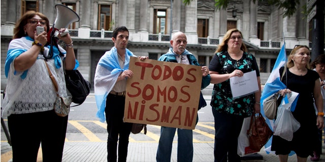 People holding a sign that reads in Spanish "We are all Nisman," protest the death of special prosecutor Alberto Nisman, outside Congress in Buenos Aires, Argentina, Monday, Jan. 19, 2015. Nisman who accused the government of secret deals with Iran over an investigation into a 1994 Argentine-Israeli Mutual Association community center terrorist attack, was found dead with a gunshot wound, at his apartment early Monday. Nisman was due to participate in a closed-door session with Congress Monday over his claim last week that Argentine President Cristina Fernandez and Foreign Minister Hector Timerman covered up a deal with Iran. (AP Photo/Rodrigo Abd)