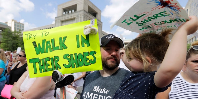 In Indianapolis, Scott Burns holds his daughter, Annelle, during a protest of the administration's approach to illegal border crossings and family separations at the border.