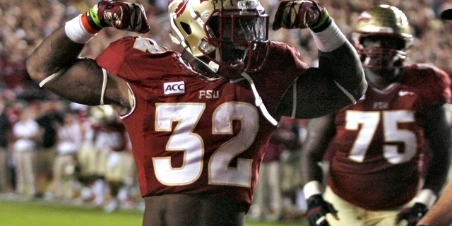 Florida State running back James Wilder Jr. (32) celebrates after scoring a touchdown against Miami during the second quarter of an NCAA college football game Saturday, Nov. 2, 2013, in Tallahassee, Fla. At right is offensive linesman Cameron Erving (75). (AP Photo/Phil Sears)