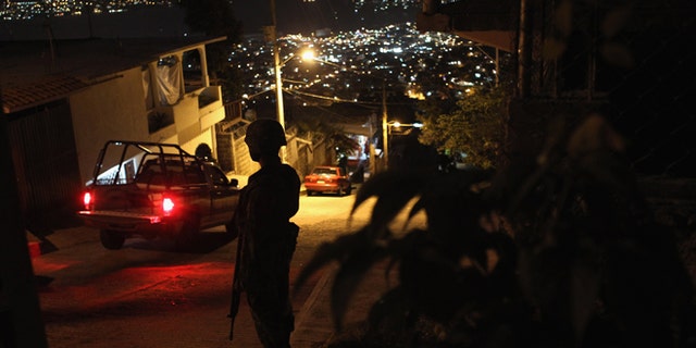 ACAPULCO, MEXICO - MARCH 03: A Mexican army soldier stands guard at a suspected drug-related murder site March 3, 2012 in Acapulco, Mexico. A forensics team excavated five corpses from the floor of an abandoned house. Officials said the five victims were apparently buried alive in concrete. Drug violence has surged in the coastal resort in the last year, making Acapulco the second most deadly city in Mexico after Juarez. One of Mexico's top tourist destinations, Acapulco has suffered a drop in business, especially from foreign tourists, due to the violence. Toursim accounts for about 70 percent of the economy of Acapulco's state of Guerrero and 9 percent of Mexico's economy. (Photo by John Moore/Getty Images)