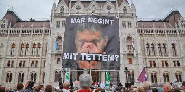 A man holds a poster of Hungarian Premier Viktor Orban that reads "What have I done again" during a protest by opposition parties against Orban's policies on migrants in Budapest, Hungary, Sunday, Oct. 2, 2016. Hungarians vote in a referendum which Prime Minister Viktor Orban hopes will give his government the popular support it seeks to oppose any future plans by the European Union to resettle asylum seekers among its member states. (AP Photo/Vadim Ghirda)