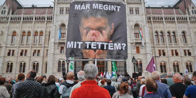 A man holds a poster of Hungarian Premier Viktor Orban that reads "What have I done again" during a protest by opposition parties against Orban's policies on migrants in Budapest, Hungary, Sunday, Oct. 2, 2016. Hungarians vote in a referendum which Prime Minister Viktor Orban hopes will give his government the popular support it seeks to oppose any future plans by the European Union to resettle asylum seekers among its member states. (AP Photo/Vadim Ghirda)