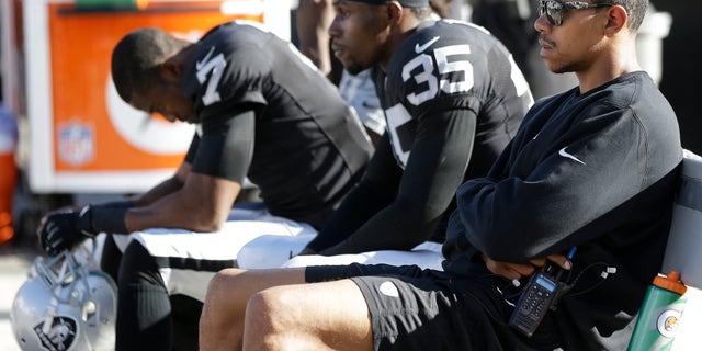 Oakland Raiders quarterback Terrelle Pryor, right, defensive back Chimdi Chekwa (35), and punter Marquette King (7) sit on the bench during the fourth quarter of the Raiders' 24-14 loss to the Washington Redskins in an NFL football game Sunday, Sept. 29, 2013, in Oakland, Calif. (AP Photo/Marcio Jose Sanchez)